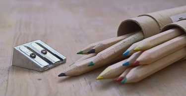 crayons de bois posés sur une table avec un taille-crayon