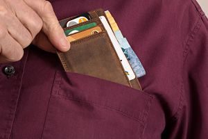 main prenant un porte-monnaie dans une poche