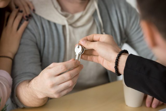 main donnant des clés à un couple